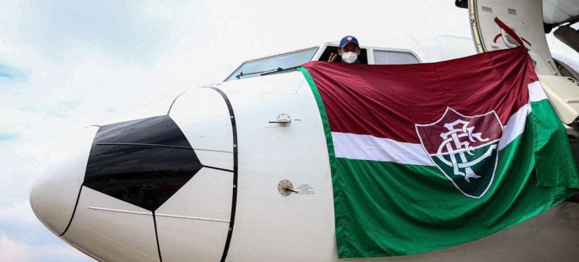 Fred surgiu ontem na cabine do avião com uma enorme bandeira tricolor - Foto: Lucas Merçon / Fluminense Fred surgiu ontem na cabine do avião com uma enorme bandeira tricolor
