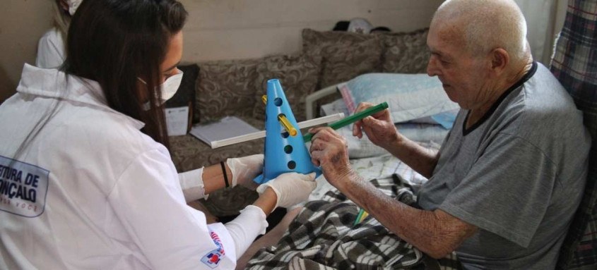 Arnaldo Ramos, de 87 anos, sob os cuidados da fisioterapeuta Jéssica Calisto