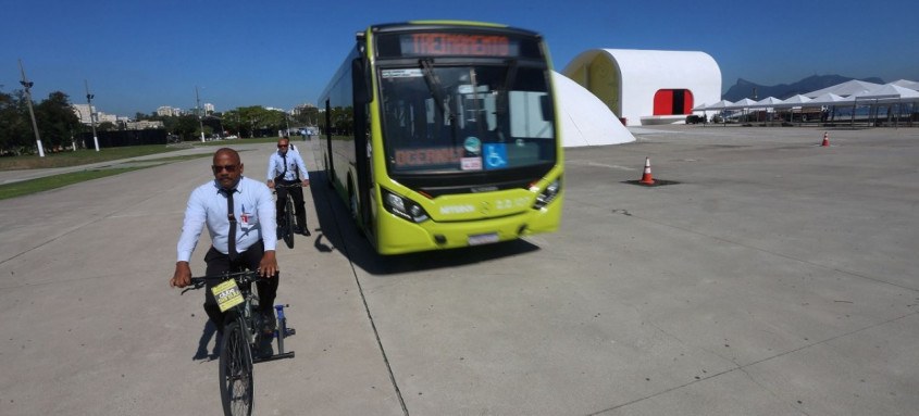 Os rodoviários assumiram o papel de ciclistas, em uma bicicleta presa ao chão, enquanto os ônibus passavam bem próximo a eles