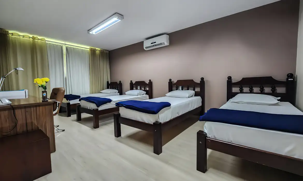Os quartos são equipados com camas individuais, televisão, mesa e cadeiras