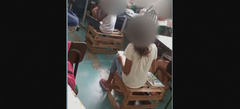 Estudantes precisam assistir aula sentados em caixotes de feira
